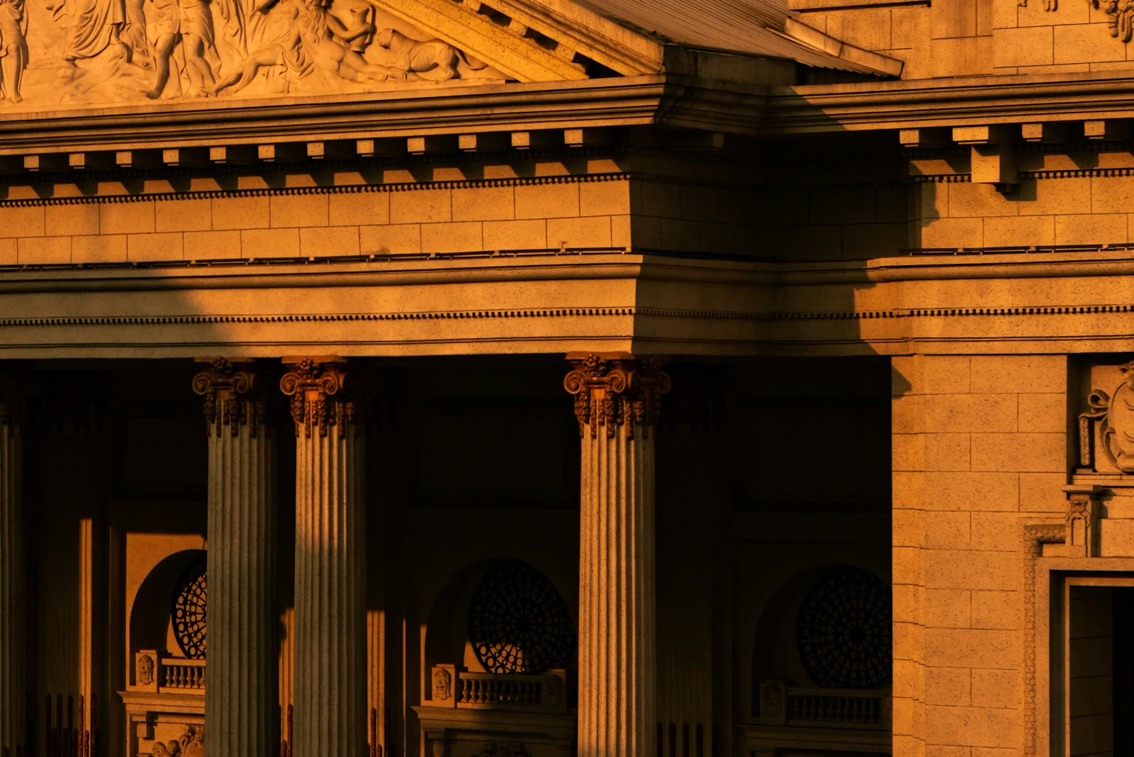 Classical stone facade with Ionic columns at golden hour
